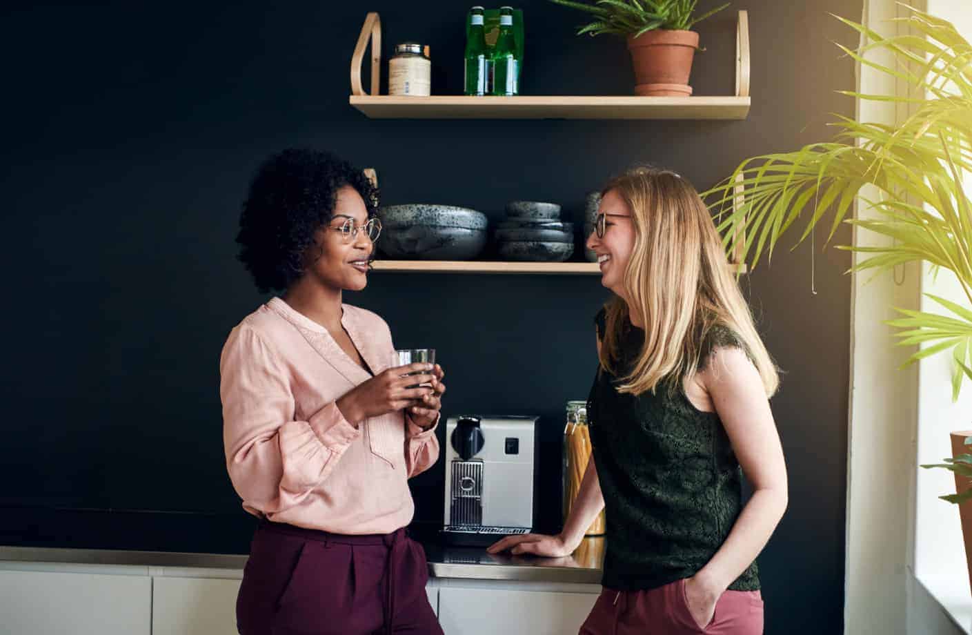 Women conversing in office kitchen