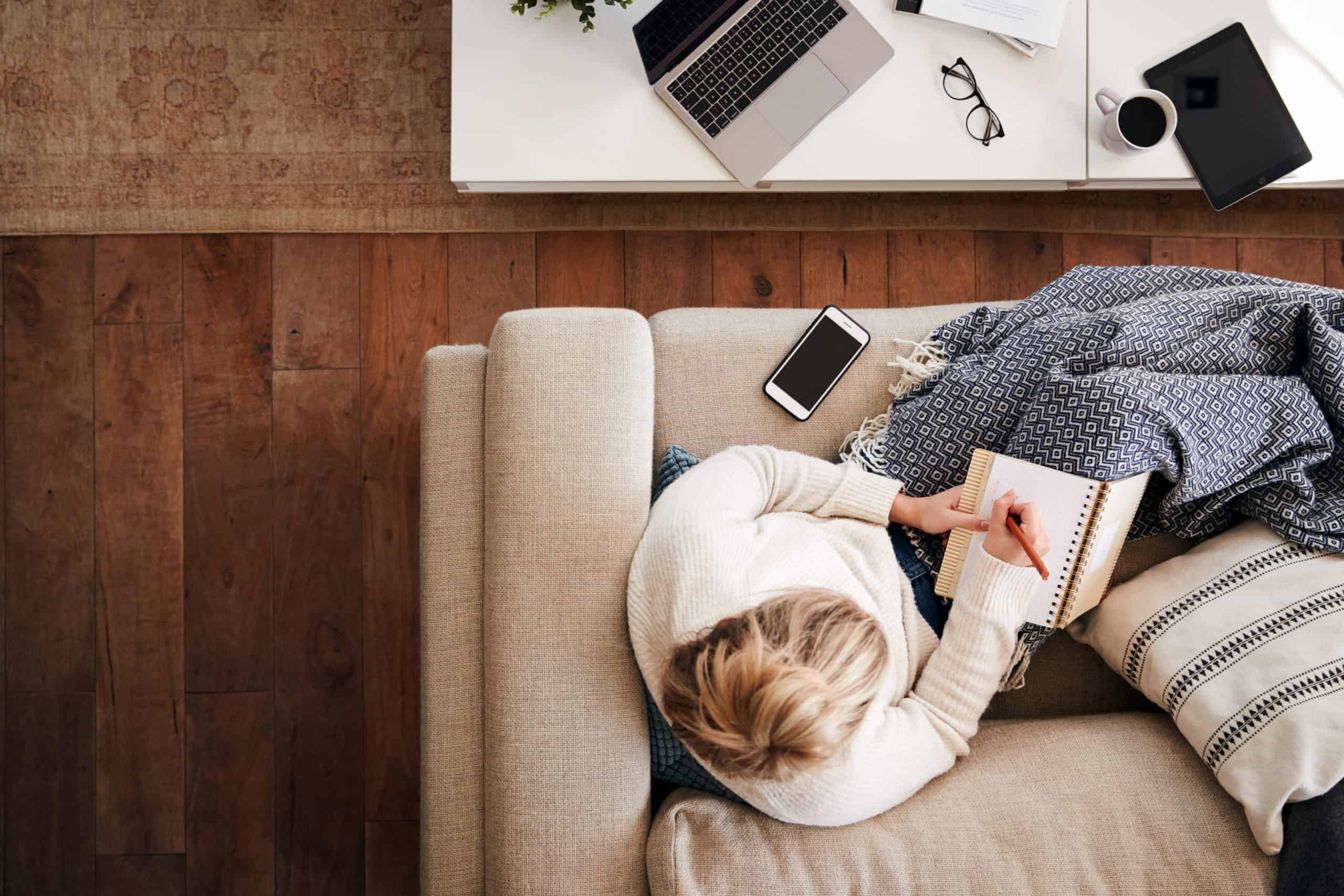 woman working from home with notebook on couch