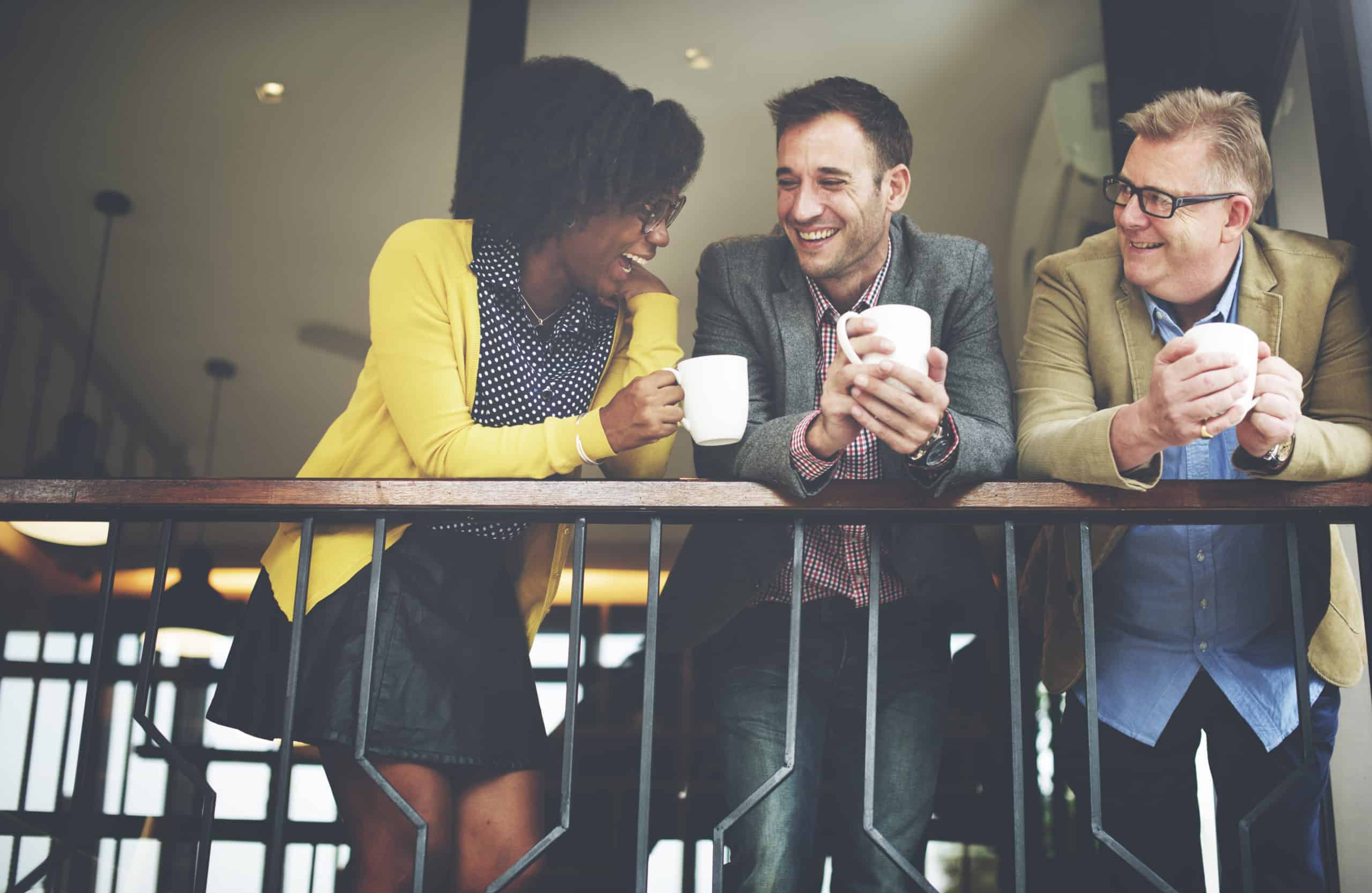 office colleagues interacting with coffee mugs