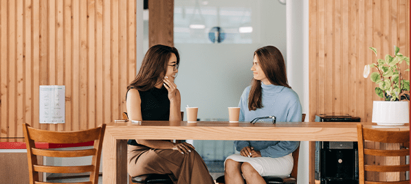 Two women talking at desk